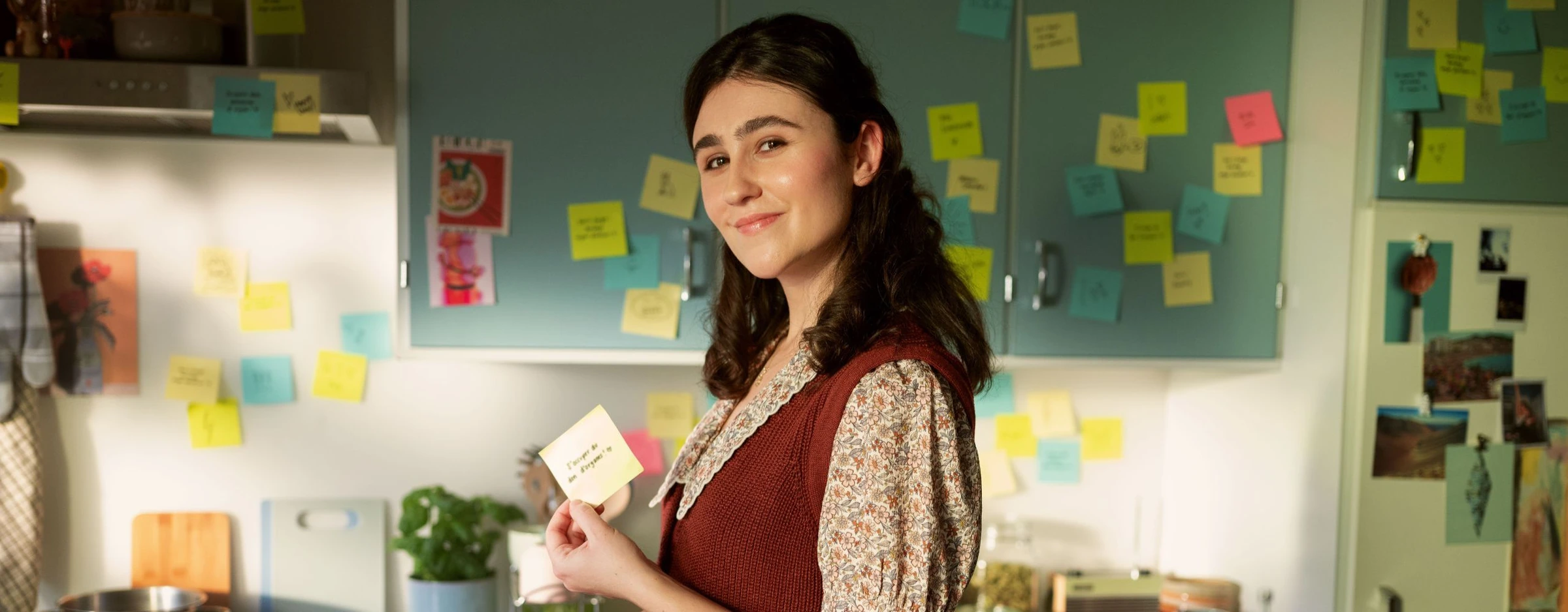 Image de campagne de l’OFSP : une femme tient une note dans une cuisine.