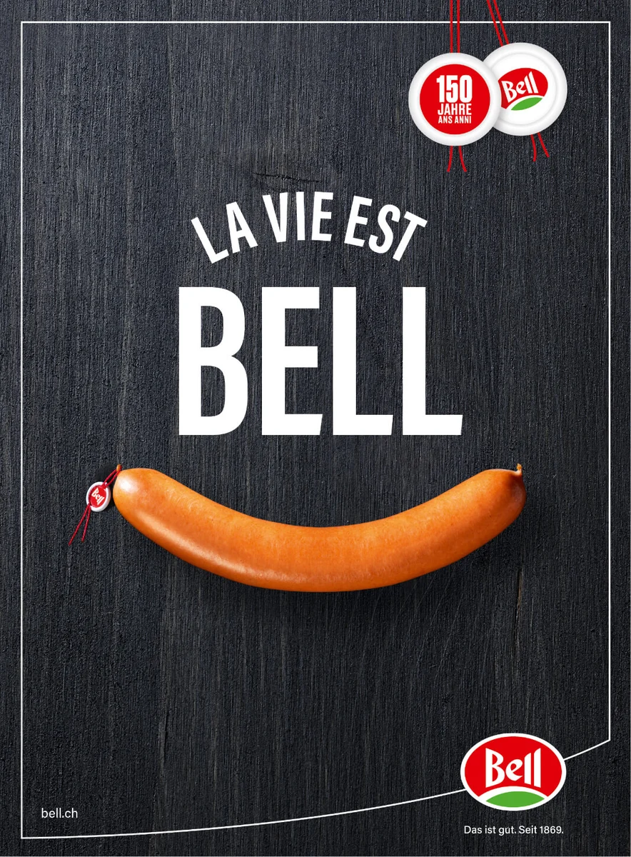 Affiche « La vie est Bell » avec une saucisse dessinant un sourire sur fond noir.