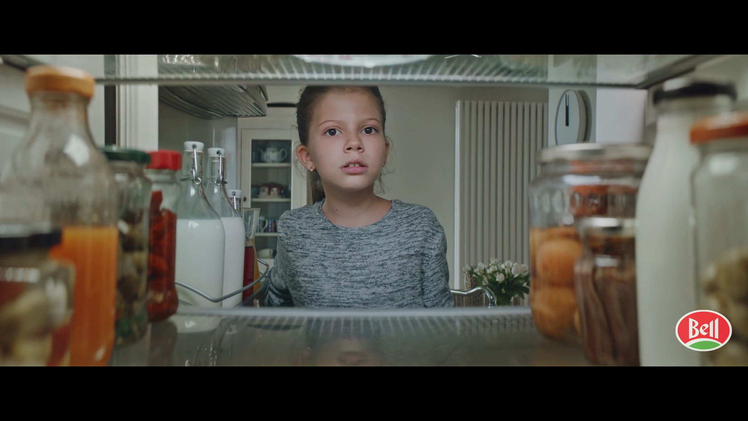 Film anniversaire Bell : une enfant regarde dans un réfrigérateur ouvert.