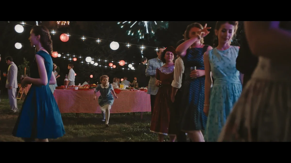 Film des 150 ans de Bell : fête de nuit en plein air sous des guirlandes lumineuses.