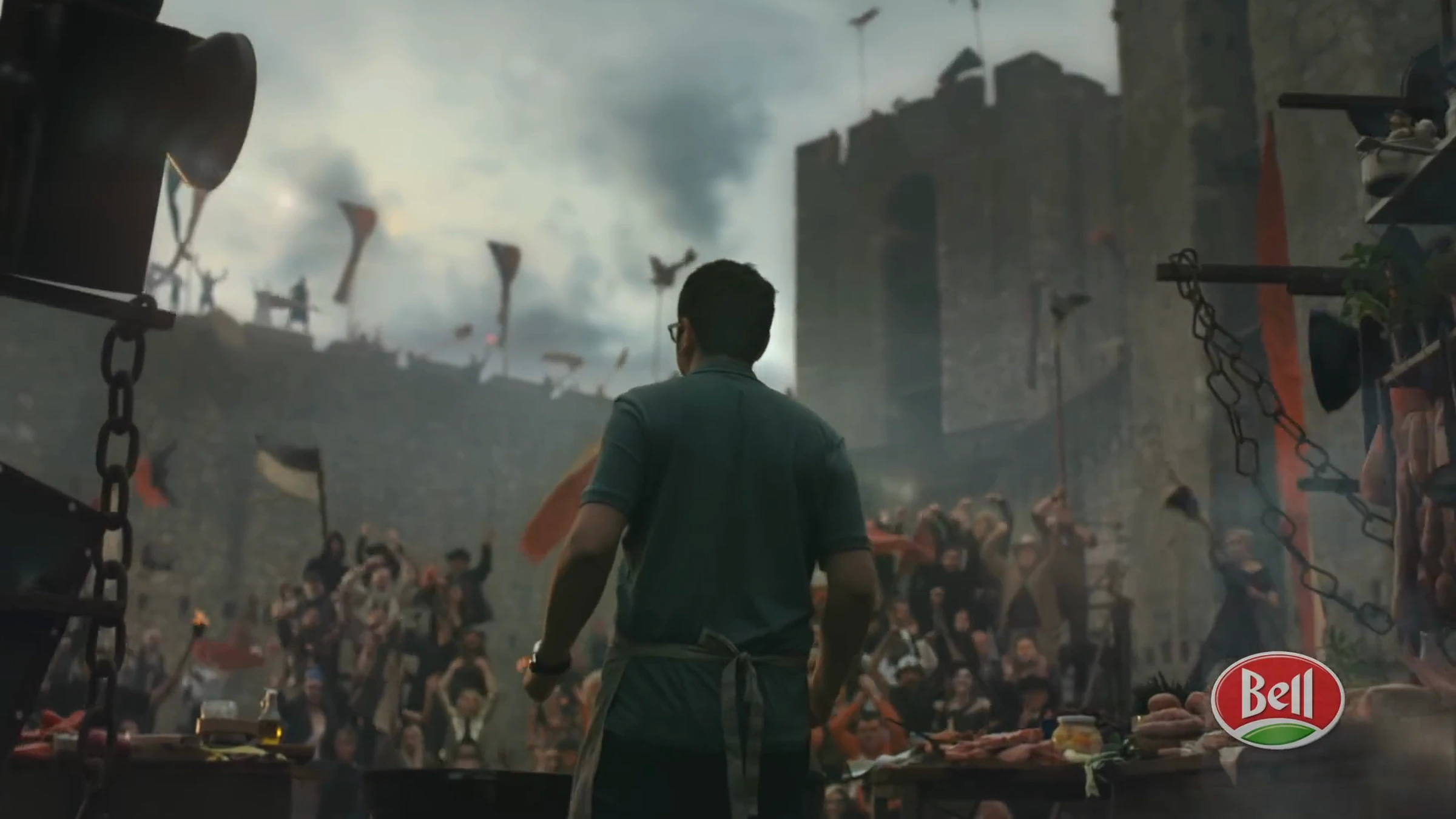 Film Bell BBQ : cuisinier de dos face à une foule dans un décor de forteresse.