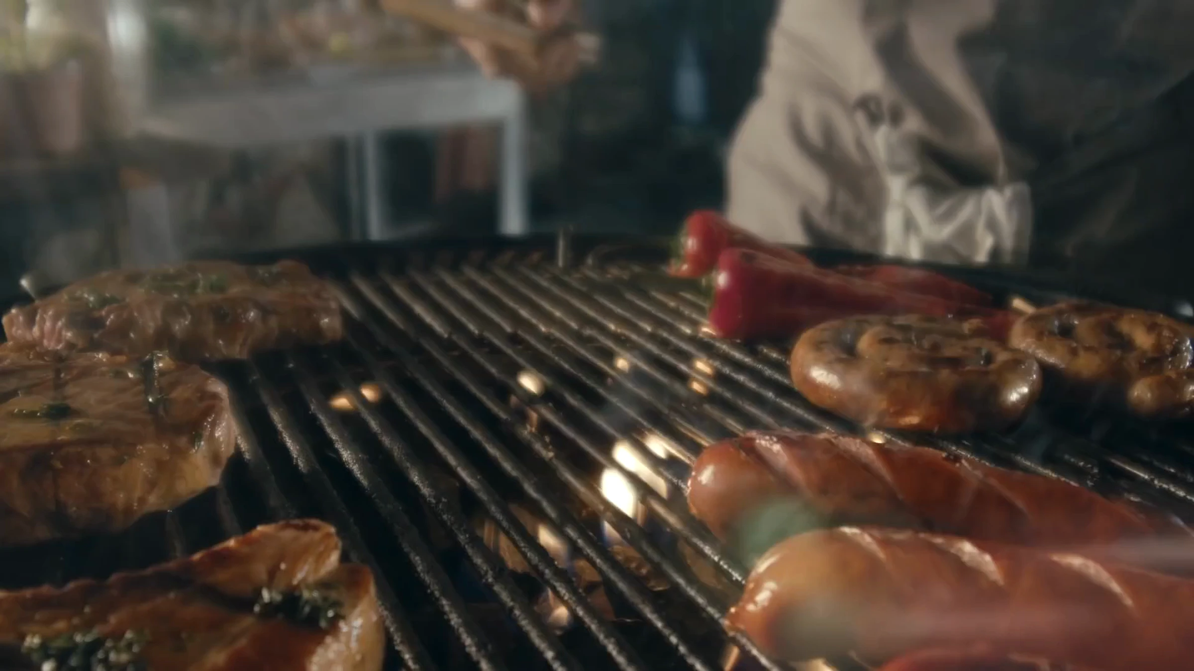 Film Bell BBQ : viandes et saucisses sur la grille du barbecue.