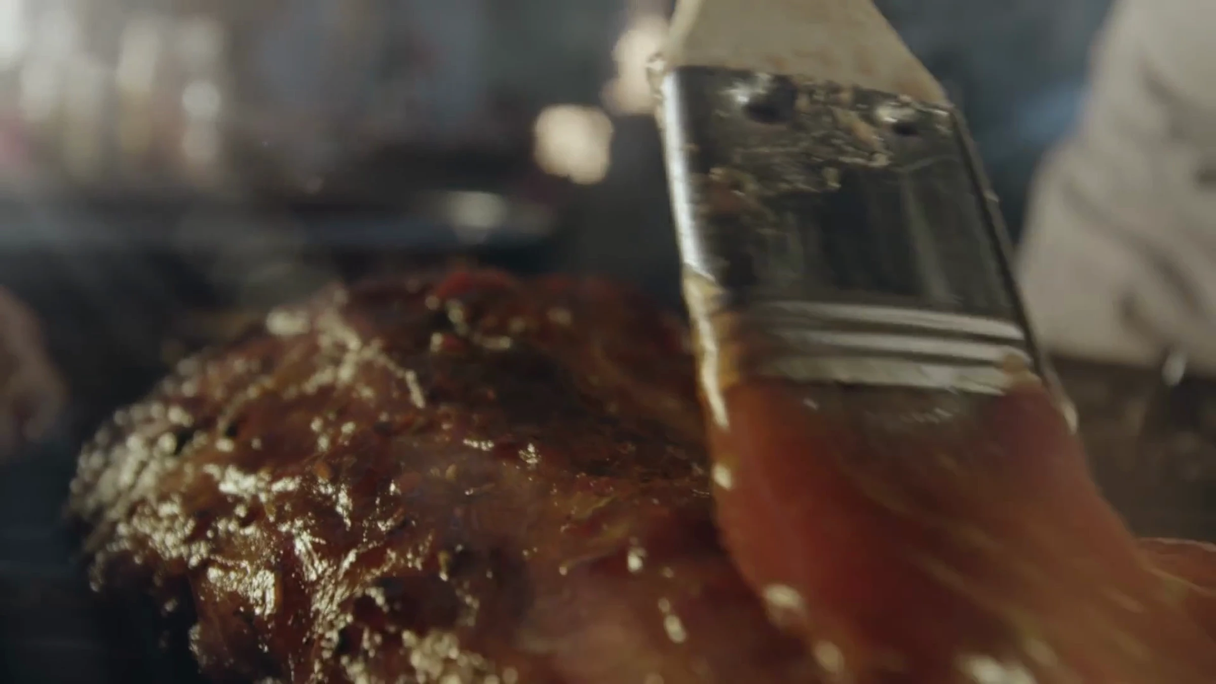 Film Bell BBQ : viande badigeonnée de sauce au pinceau.