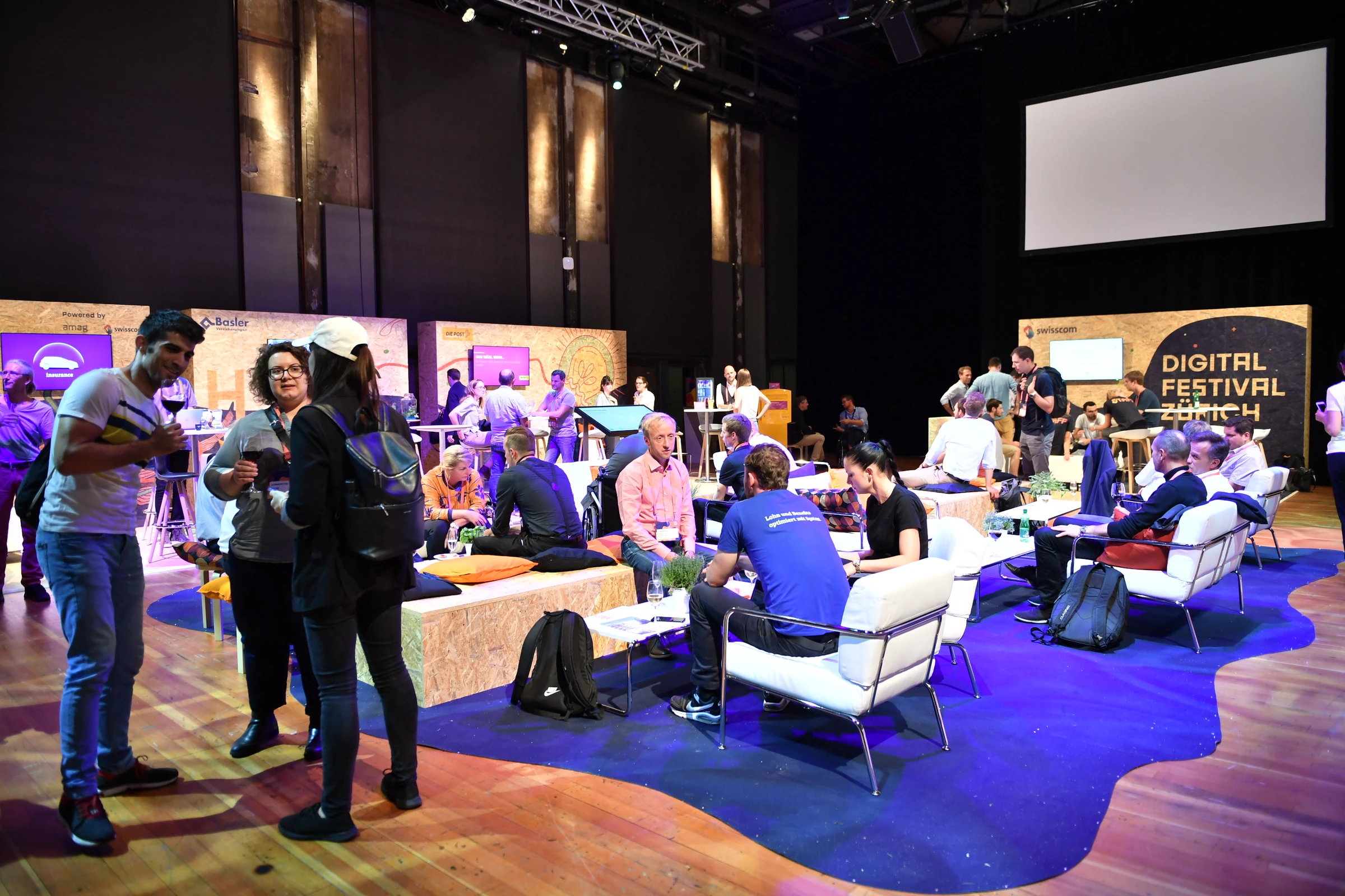 Espace de rencontre du Digital Festival avec mobilier clair et moquette violette.