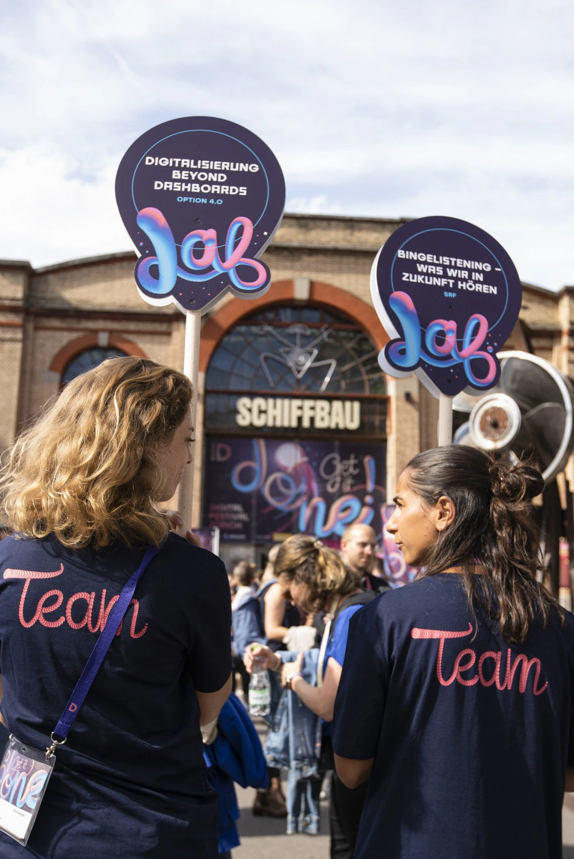 Membres de l’équipe du Digital Festival avec panneaux de guidage illustrés.