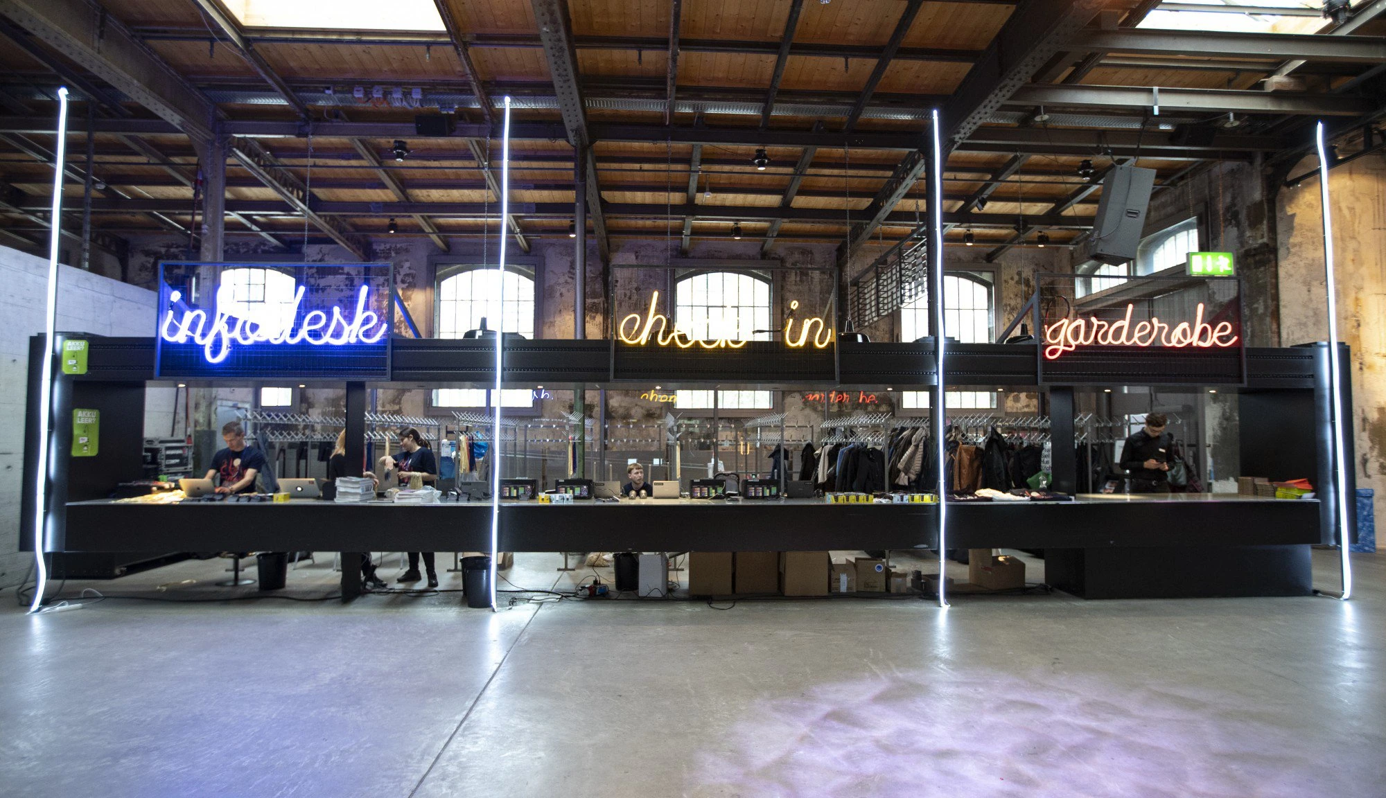 Comptoirs d’information, d’accueil et de vestiaire avec enseignes lumineuses.