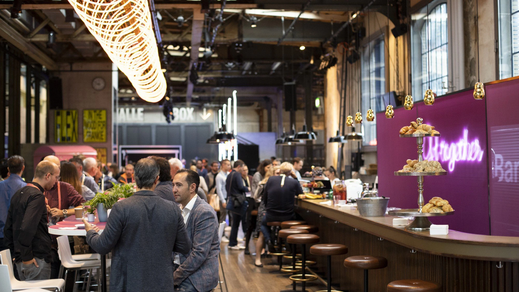 Bar du Digital Festival avec décor violet et suspensions lumineuses.
