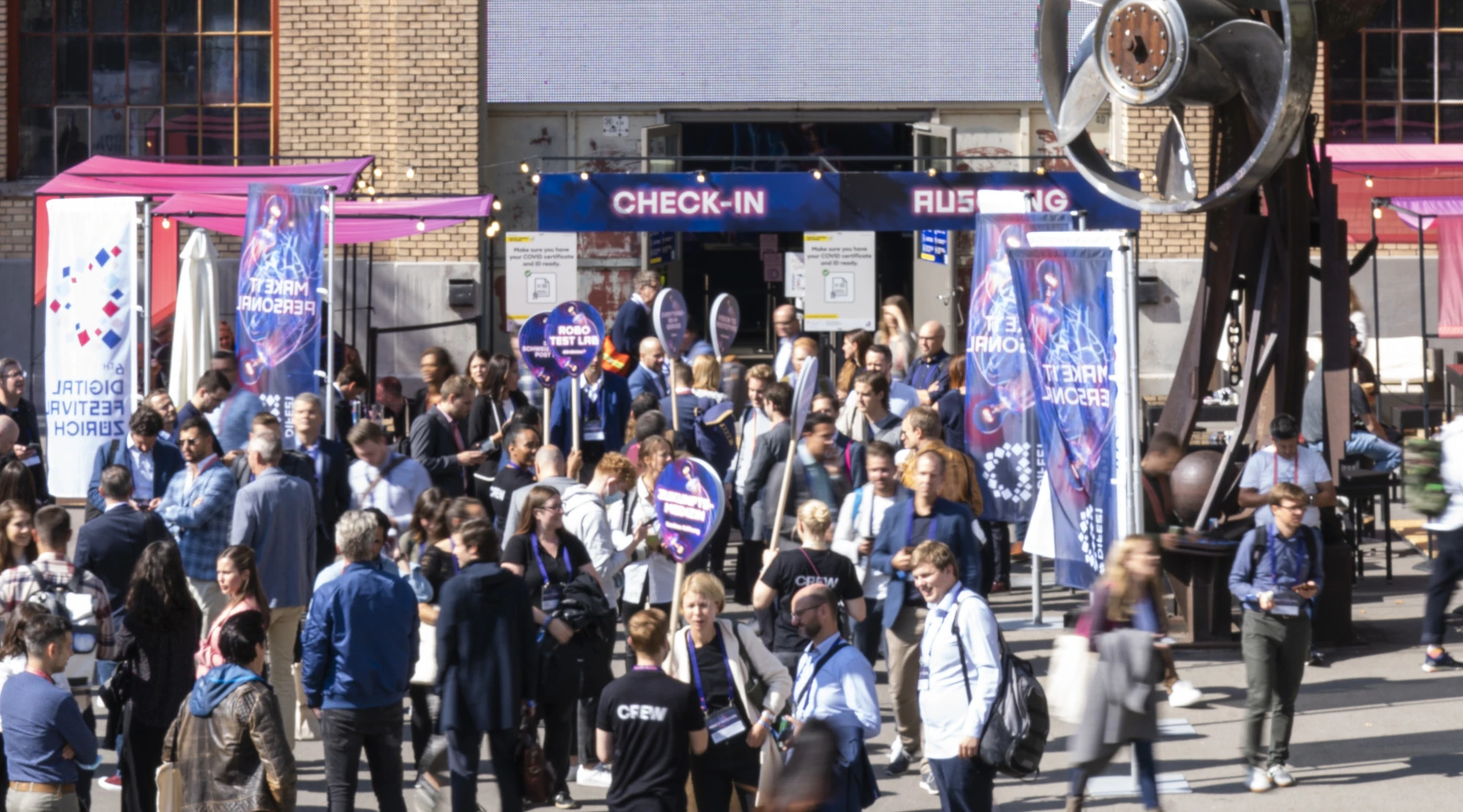Zone d’accueil du Digital Festival 2021 avec drapeaux et panneaux de guidage.