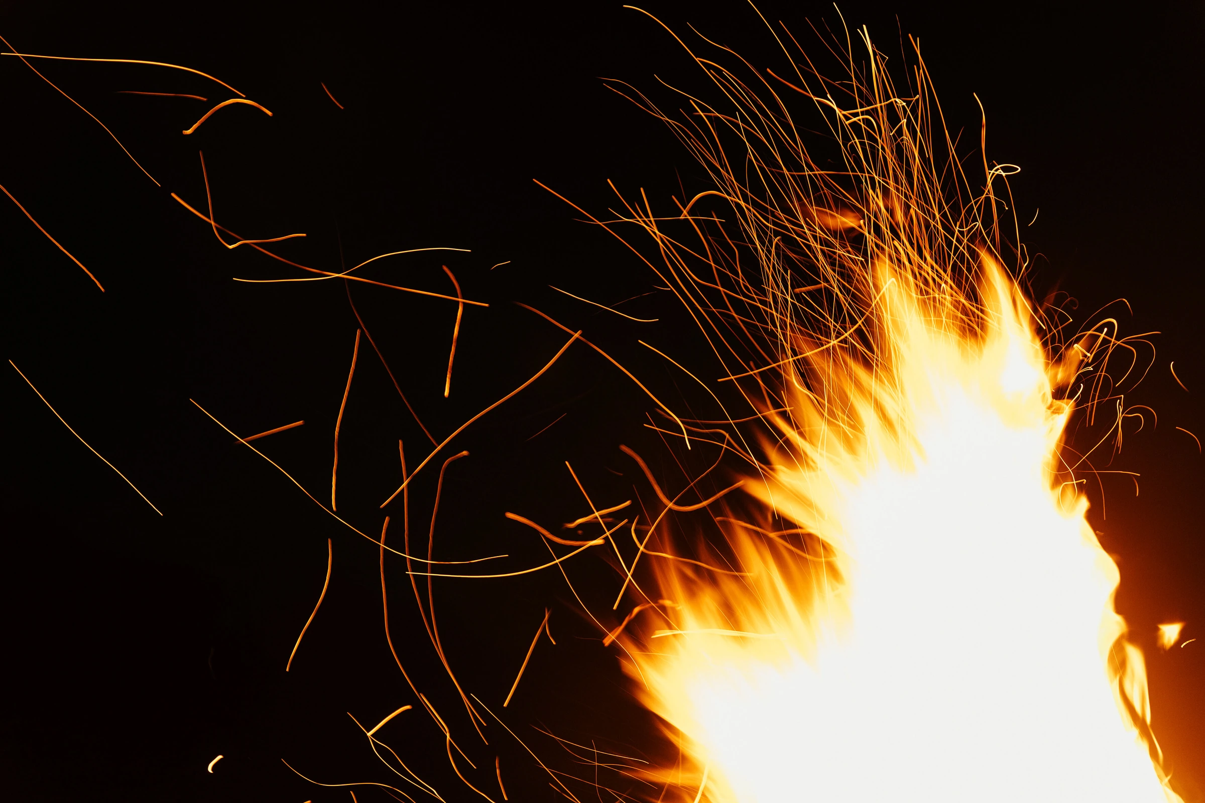 Flammes et traînées d’étincelles sur fond noir, photographie Guarda Val.