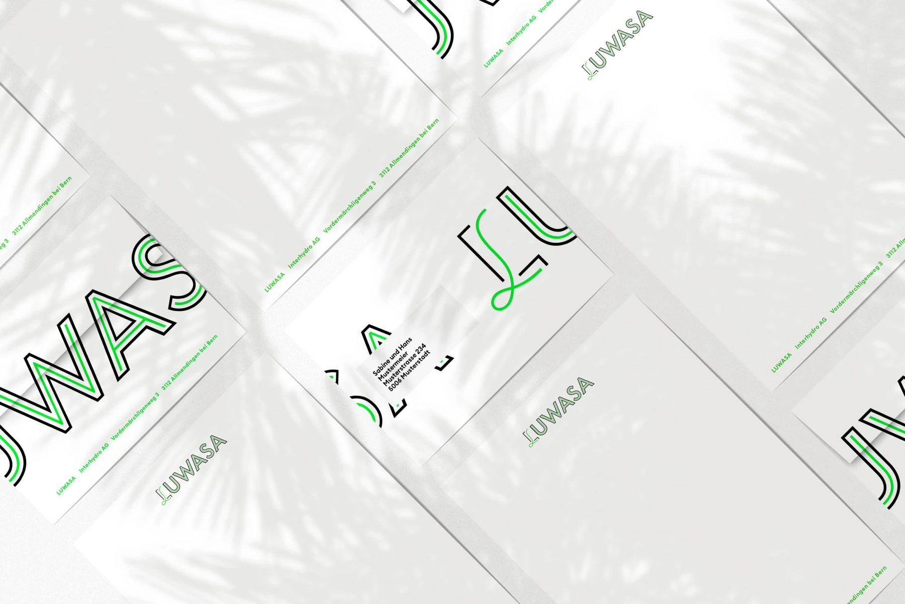 Enveloppes Luwasa blanches avec fragments du logo en contour.