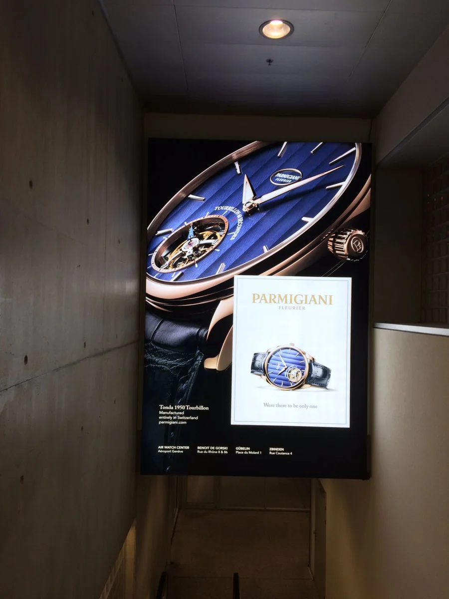 Affiche verticale Parmigiani Fleurier avec gros plan d’une montre bleue.