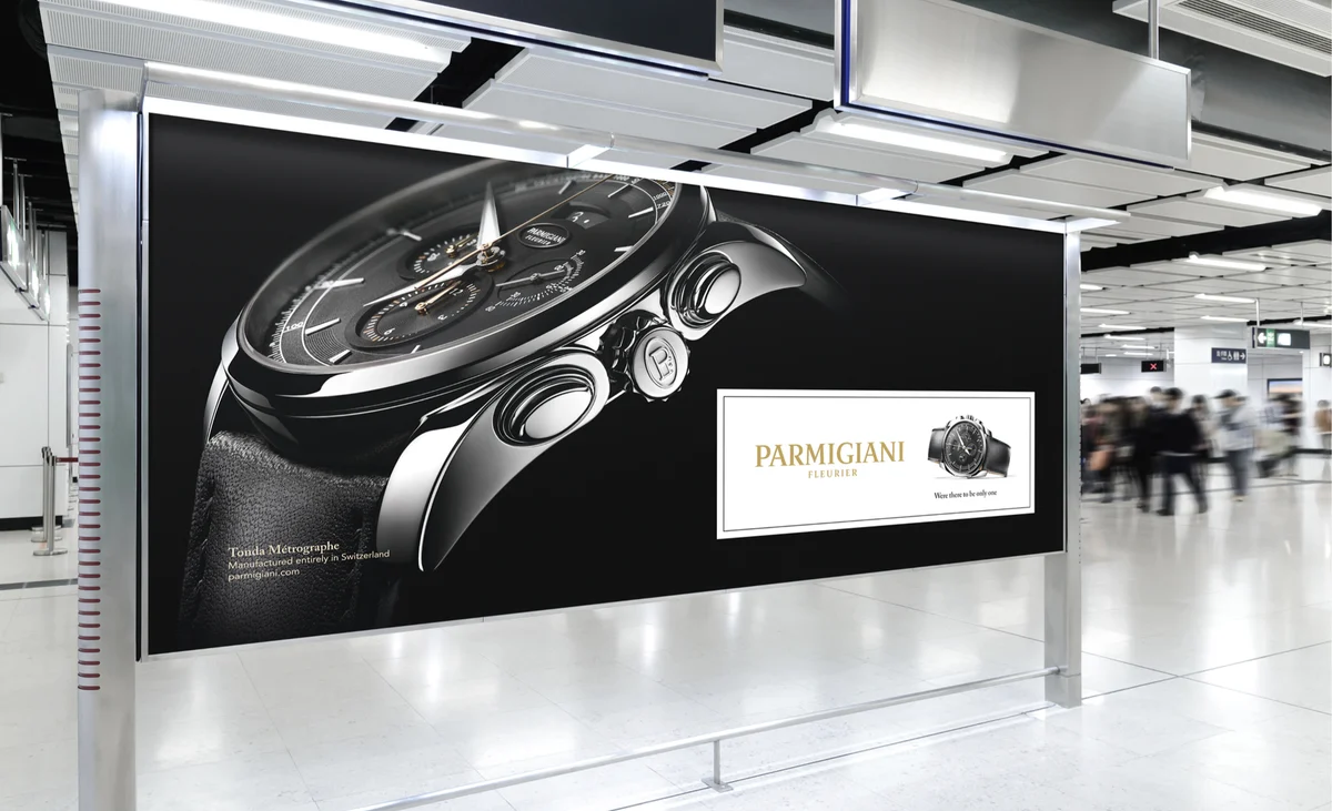 Grande affiche Parmigiani Fleurier avec montre noire dans un hall d’aéroport.