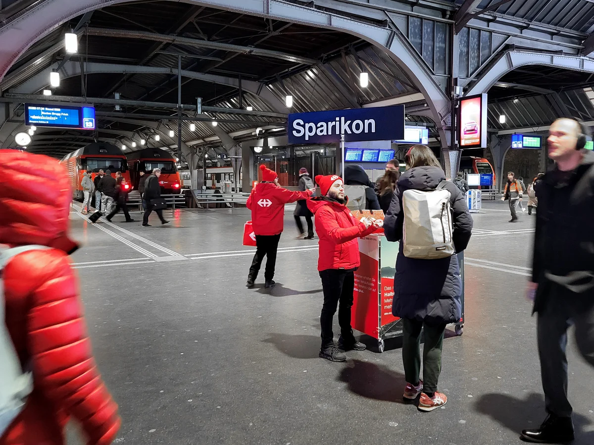 Animation promotionnelle CFF « Sparikon » dans une gare, avec équipe en rouge.