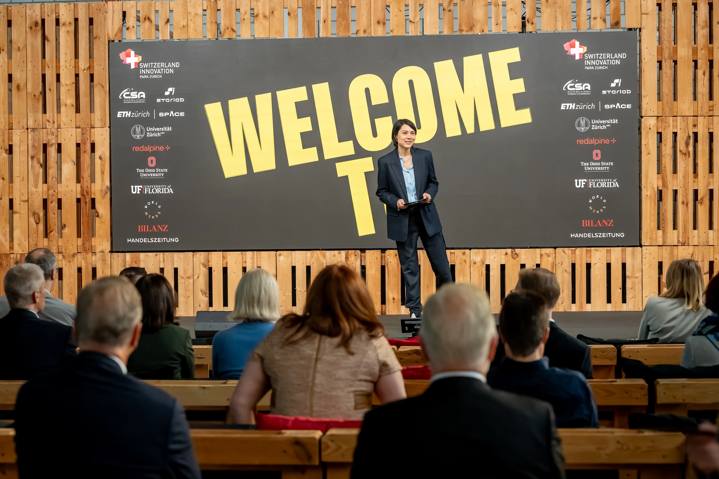 Intervenant devant le grand panneau « Welcome to » du 8th Continent Forum.