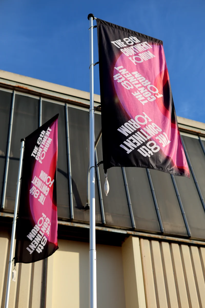 Drapeaux roses et noirs du 8th Continent Forum devant le lieu de l’événement.