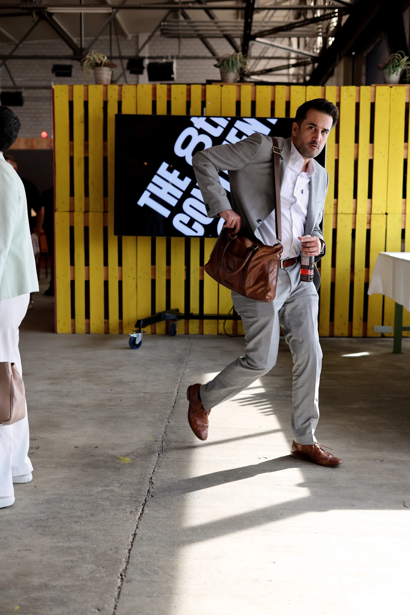 Participant devant un écran du forum intégré à une paroi jaune.
